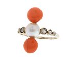 un gros plan d'une bague ornée d'une perle et d'un corail