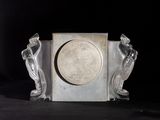 a silver clock sitting on top of a black table