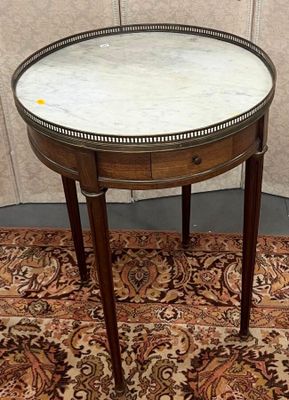 une petite table avec un plateau en marbre posée sur un tapis