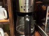 une cafetière posée sur une table en bois à côté d'une autre cafetière