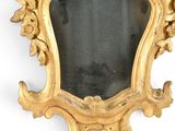 a mirror with a gold frame on a white wall