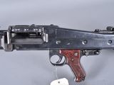 an old machine gun with a tag hanging from it ' s side