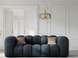 un grand canapé bleu placé dans un salon, près d'un mur blanc