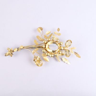 a gold flower brooch on a white background