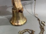une cloche attachée à une chaîne, posée sur une table