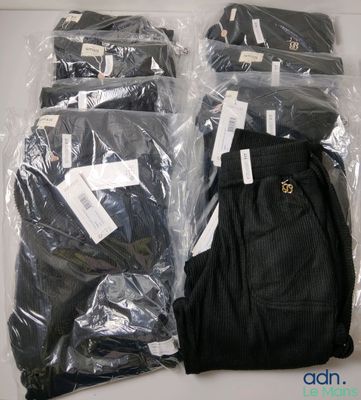 four pairs of pants wrapped in plastic bags on a table
