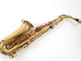 an image of a gold saxophone with a black cord on a white background
