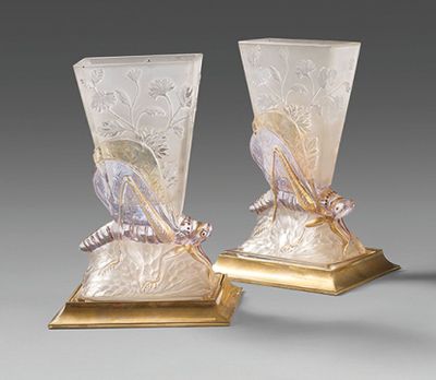 pair of glass vases with a gold base and a bird decoration