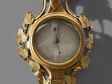 a gold clock on the wall with a bird on it