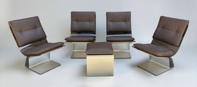 trois fauteuils en cuir marron et une petite table dans une pièce blanche