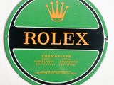 une image représentant l'enseigne Rolex verte et noire sur un mur blanc