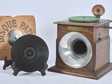 une petite boîte en bois sur laquelle est posé un disque, à côté d'une vieille radio