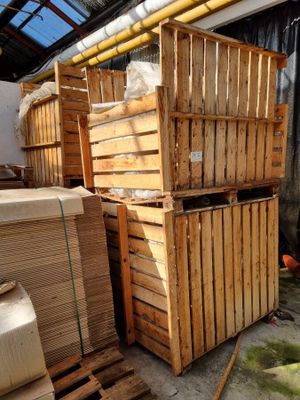plusieurs caisses en bois empilées les unes sur les autres dans un entrepôt
