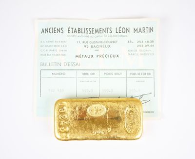 a gold bar sitting next to a receipt on a table
