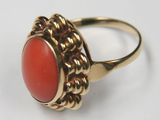 a close up of a gold ring with a red stone