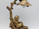 an antique bronze figurine of a woman and child on a branch with a lamp