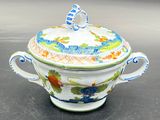 a white and blue bowl with a lid on a table
