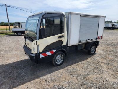 un petit camion garé sur un terrain en terre battue