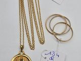 a close up of a gold necklace and two rings on a table