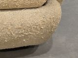 a cat that is sitting on a chair that is made out of fabric
