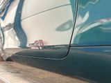 a close up of a blue car with a small red object on the side