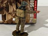 figurine of a man in a military uniform standing next to a box