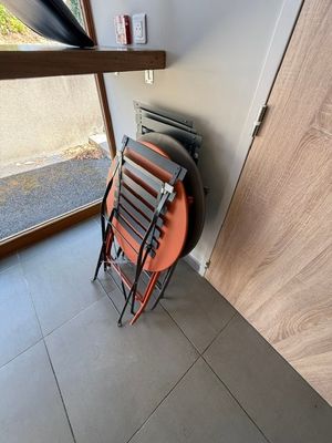 une pile de chaises devant une porte et une fenêtre