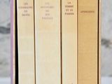 three books in a box on a table with a white background