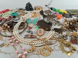 many different necklaces and bracelets on the table