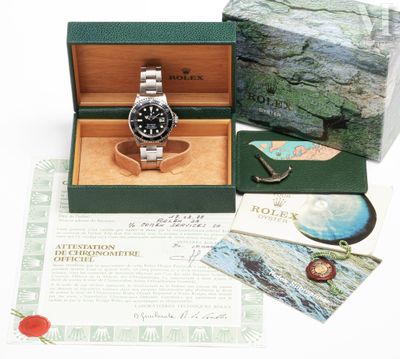 a rolex watch in a box with a brochure in the background