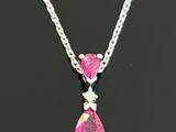 a close up of a necklace with pink stones on a black surface