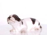 une petite figurine représentant un chien posée sur une surface blanche