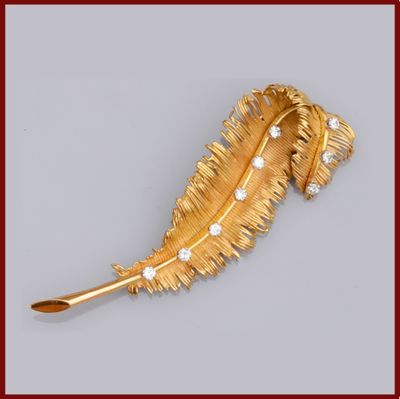 une image représentant une broche en forme de plume, en or et diamants