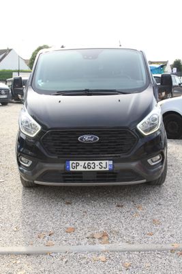 une voiture noire garée dans un parking à côté d'autres voitures