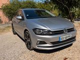 the silver volkswagen polo is parked on the side of the road