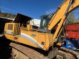 a yellow excavator that is sitting in the dirt