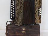 an image of an old accordion sitting on top of a wooden box