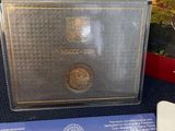 an image of a silver coin sitting on top of a table next to a box