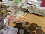 a pile of money sitting on a table next to a pile of coins