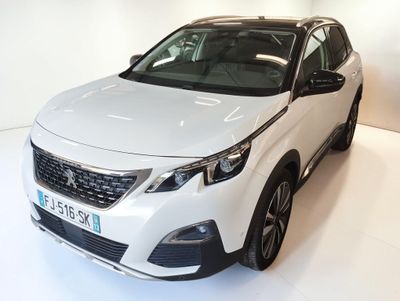 the white car is parked on the white floor in the showroom