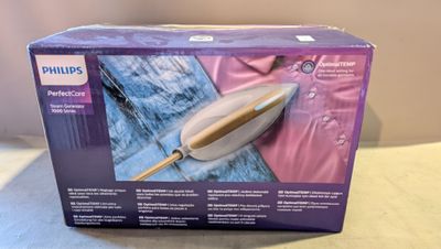La boîte de l'aspirateur Philips est ouverte sur la table.