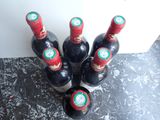 several bottles of wine are lined up on a counter top