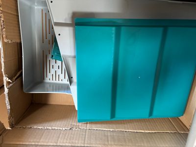 un récipient bleu placé à l'intérieur d'une boîte en carton