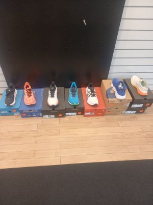 several pairs of shoes lined up on a shelf in front of a tv