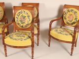 three wooden chairs with yellow and green floral designs on them