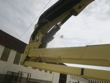 a large yellow crane that is parked in front of a building