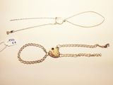 two pieces of jewelry that are laying on a table