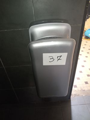 une photo d'une salle de bains avec un distributeur de papier toilette fixé au mur