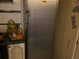 un réfrigérateur dans un coin de la cuisine, à côté d'un évier