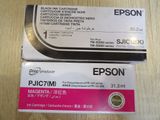 two black and pink ink cartridges sitting on top of a wooden table